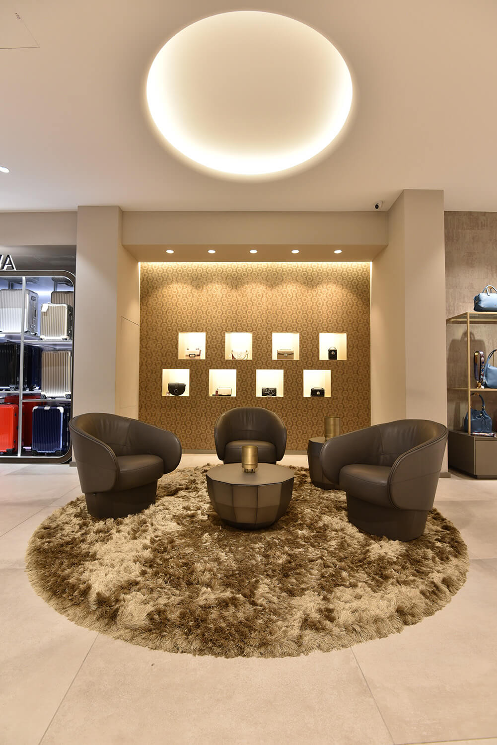 Moderner Loungebereich mit Ledersesseln und rundem Teppich in eleganter Beleuchtung