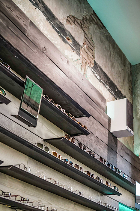 Brillenregal an rustikaler Wand in modernem Boutique-Store