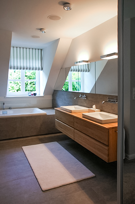 Modernes Badezimmer mit Doppelwaschbecken, Badewanne und Tageslicht durch Fenster