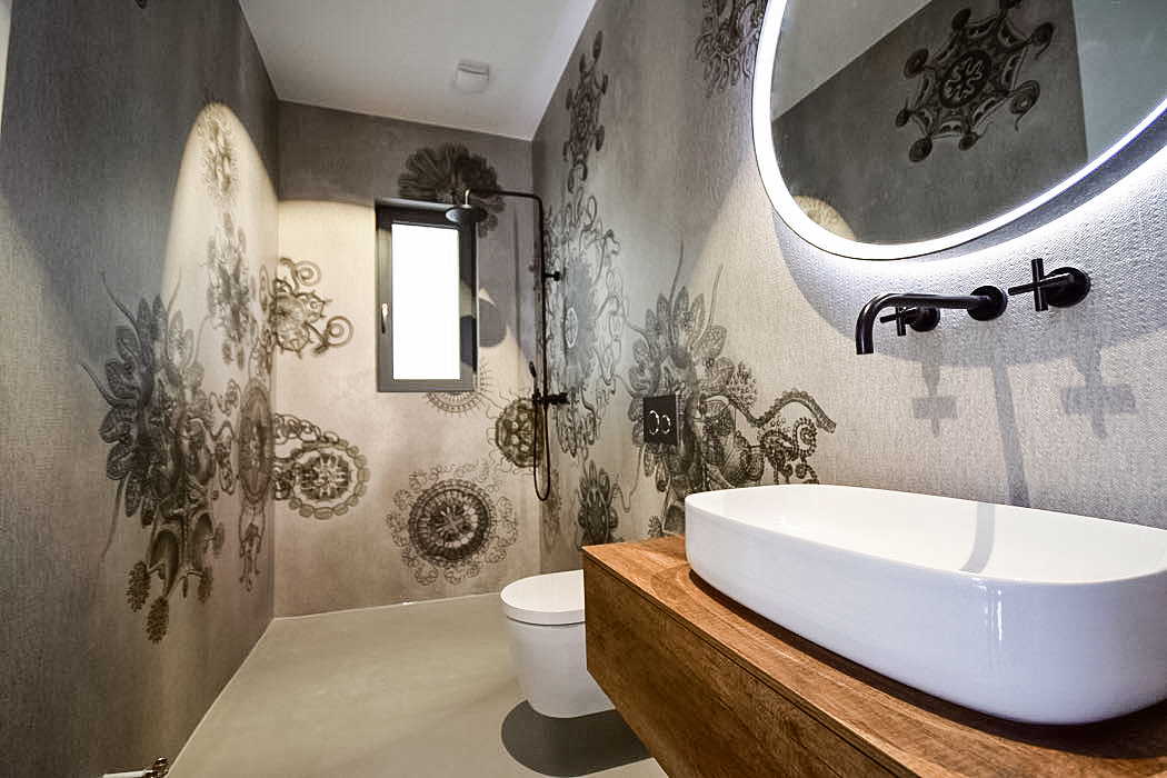 Modernes Badezimmer mit floralen Wandmotiven und beleuchtetem Spiegel