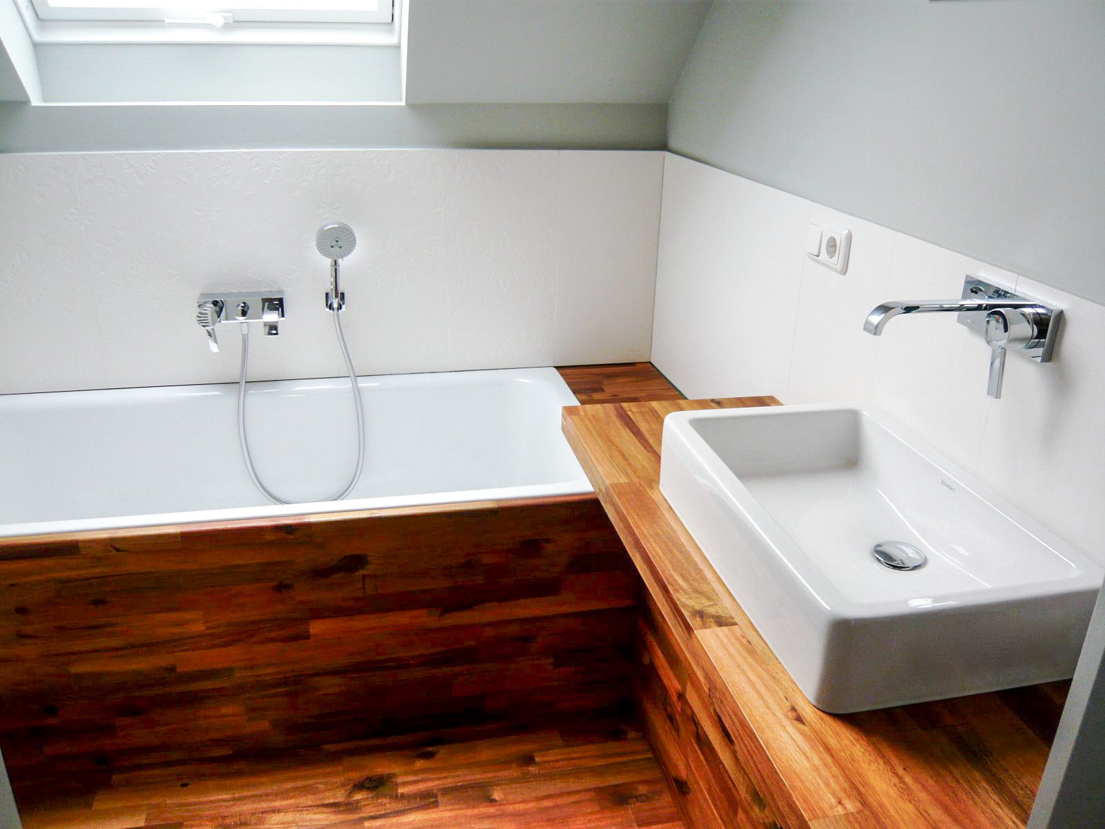 Modernes Badezimmer mit Holzverkleidung und weißen Badarmaturen