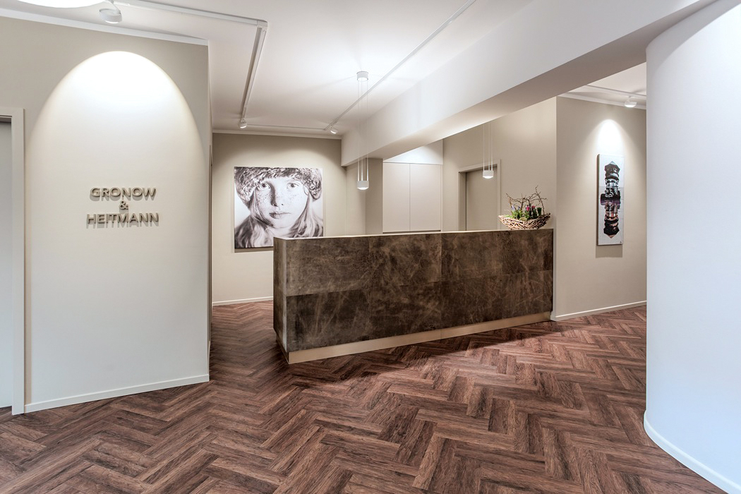 Modernes Empfangsbereich-Design mit hölzernem Fischgrätboden und Kunst an der Wand